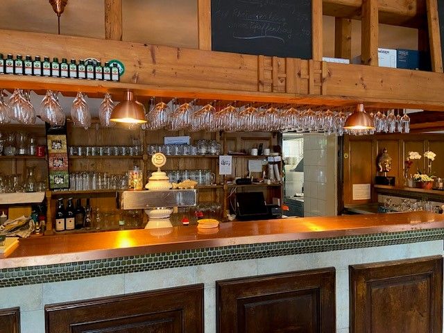Innenansicht einer rustikalen Bar mit Holzdekor und Gläsern.