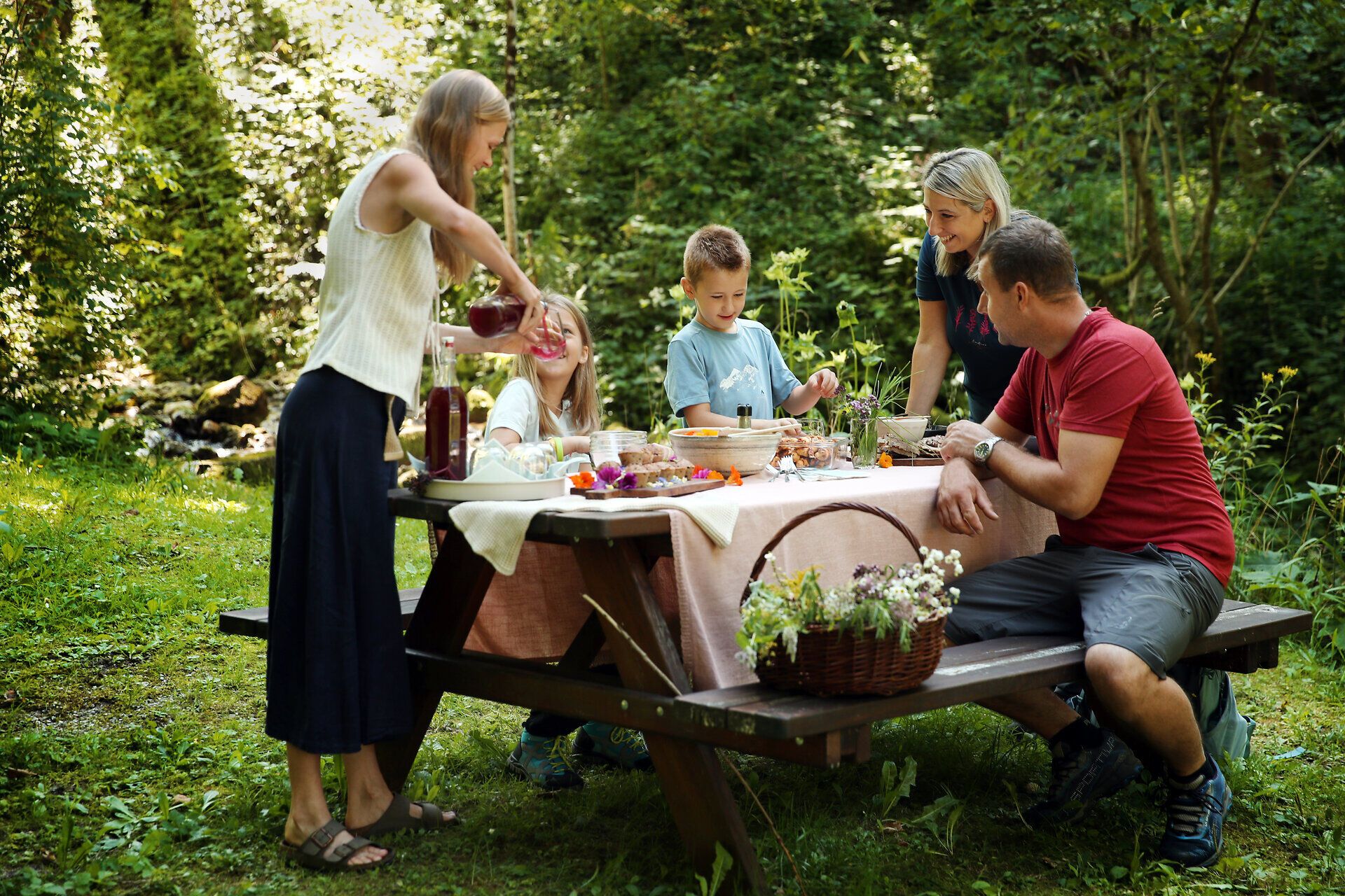 Im Zuge eine Workshops im Naturpark Falkenstein werden von einer Naturvermittlerin und einer teilnehmenden Familie Wildkräuter verarbeitet. 
