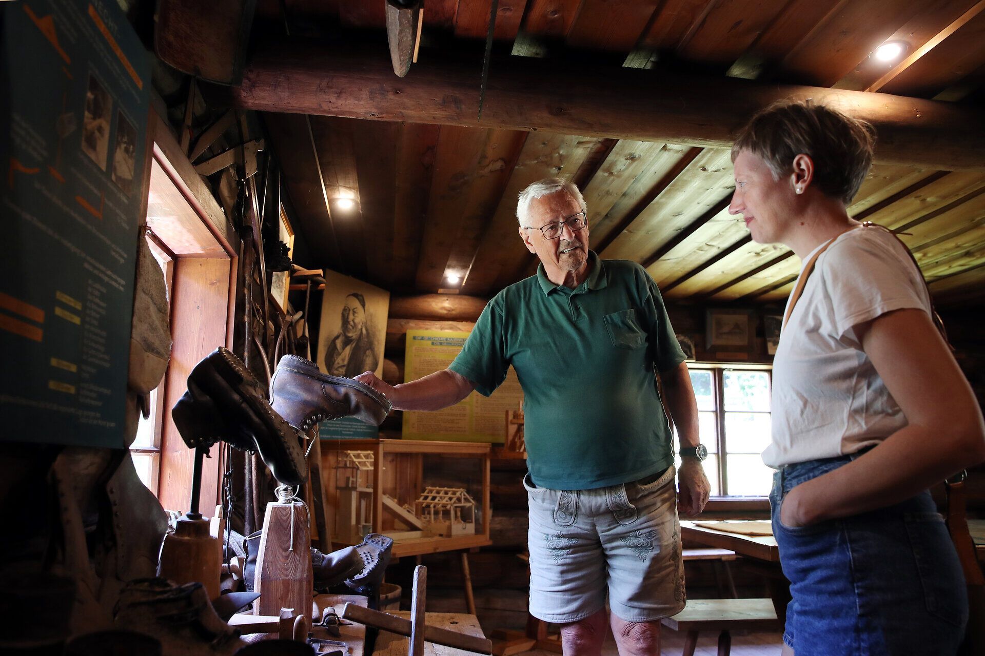 Ein Herr zeigt einer Frau die Ausstellung rund um die Holzgewinnung in der Hubmer Gedächtnisstätte im Naturpark Falkenstein.