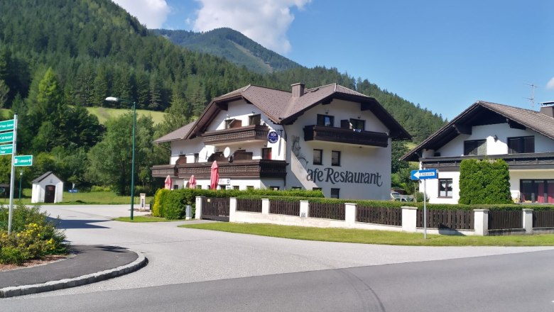Ein Caf&eacute;-Restaurant in einer l&auml;ndlichen Gegend mit Bergen im Hintergrund.